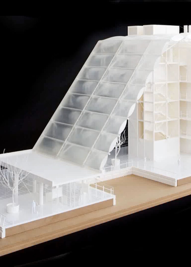 White architectural model of Midland Metropolitan University Hospital (MMUH) showing the distinctive angular roof structure and multi-level building design on wooden base