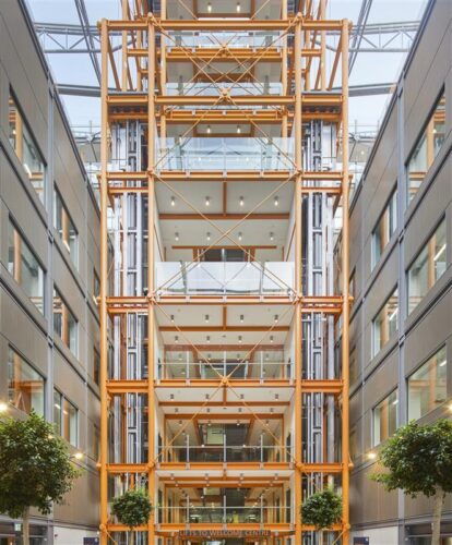 Five-story timber-framed central core featuring stairs and elevators in the winter garden atrium of Midland Metropolitan University Hospital with natural lighting